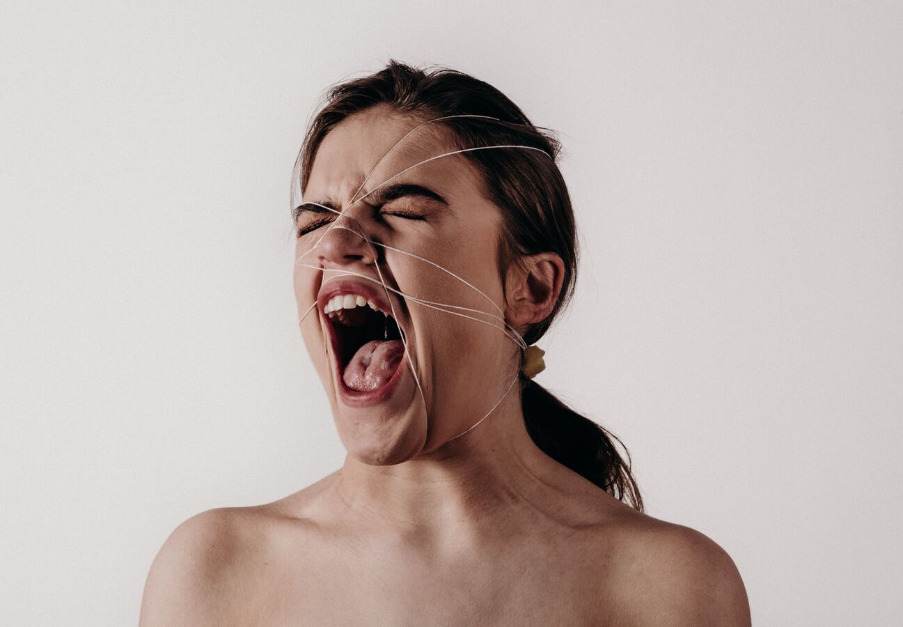 Mujer grita con cuerda en la cara.