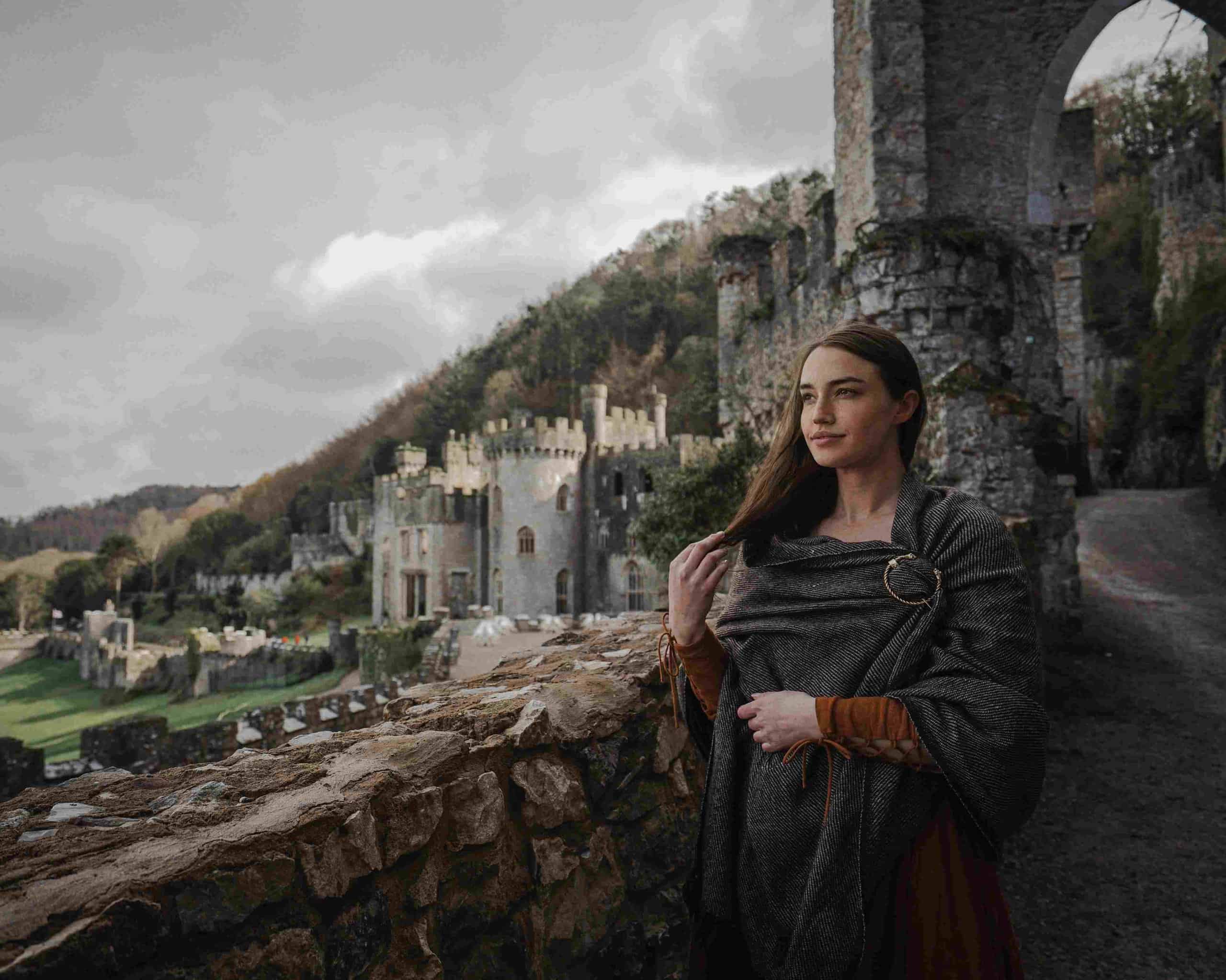Mujer sonr&iacute;e en la Edad Media, con un castillo al fondo.